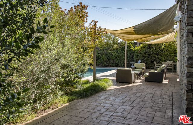 a view of a patio with table and chairs potted plants with floor to ceiling window and potted plants