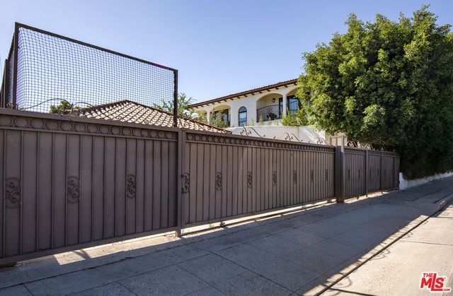 a view of a house with a wooden fence