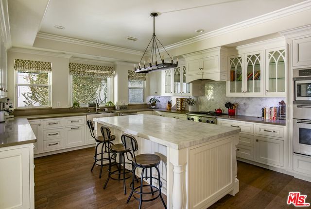 a kitchen with a table chairs stove and cabinets