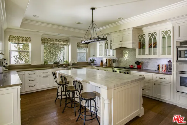 a kitchen with a table chairs stove and cabinets