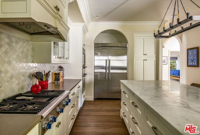 a kitchen with stainless steel appliances granite countertop a stove and cabinets