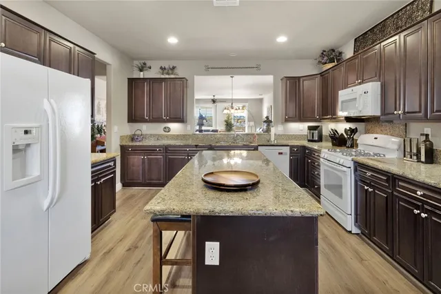 a kitchen with stainless steel appliances granite countertop a sink stove refrigerator and cabinets