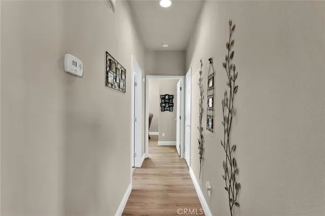 a view of a hallway with wooden floor and entryway