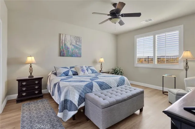a bedroom with bed and a flat tv screen on the dresser
