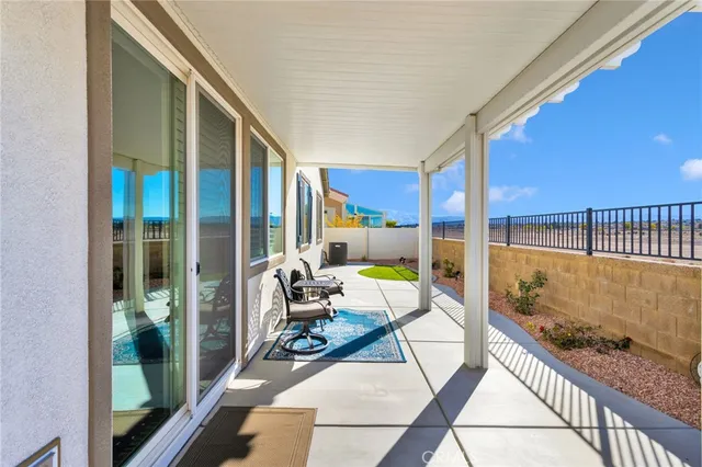 a view of a patio with table and chairs with wooden floor and fence