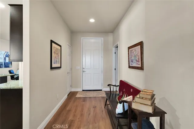 a view of a hallway with workspace and wooden floor