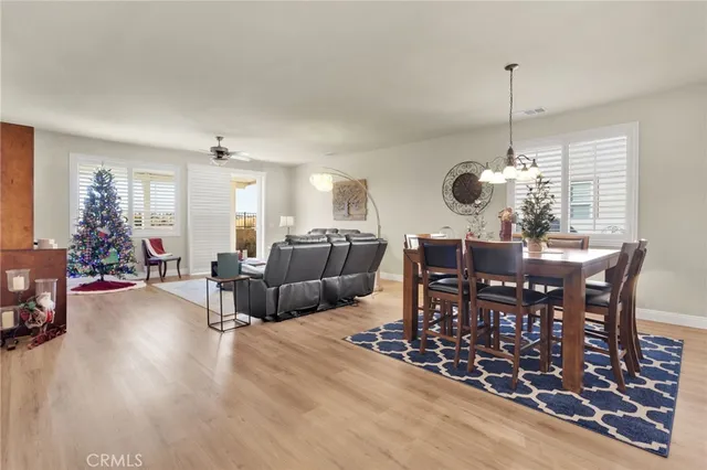 a view of a dining room and livingroom with furniture wooden floor a chandelier