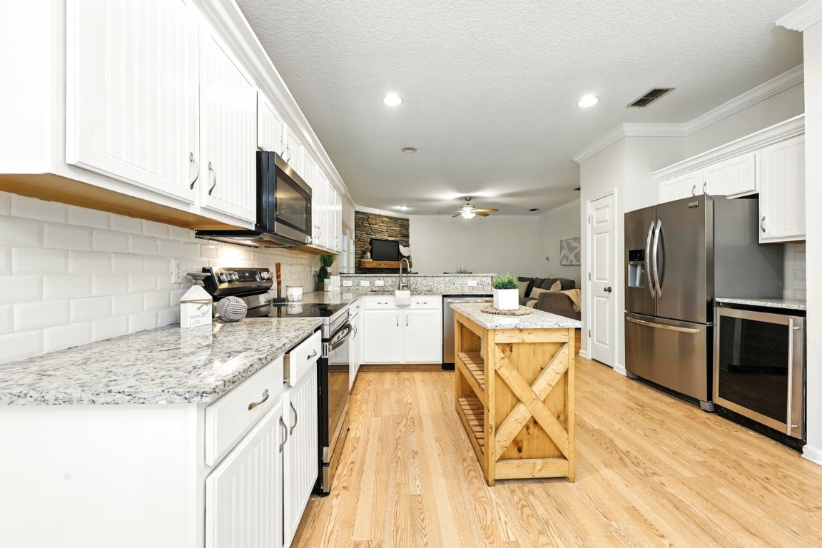 86168 Remsenburg Drive Fernandina Beach, FL 32034 - Photo 8 of 68 a kitchen with stainless steel appliances granite countertop a refrigerator a sink dishwasher a stove and white countertops with wooden floor