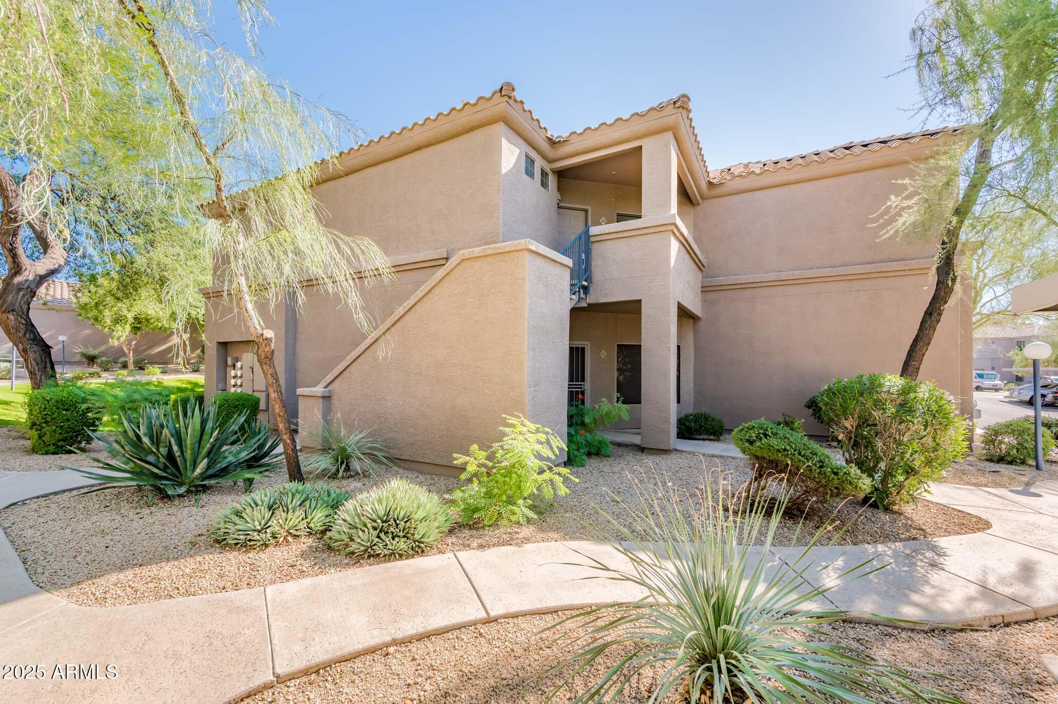 11680 East Sahuaro Drive, Unit 2021 Scottsdale, AZ 85259 - Photo 13 of 51 a front view of a house with a yard and potted plants