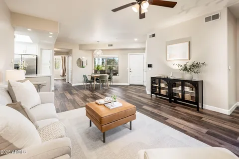 a living room with furniture and a wooden floor