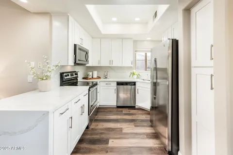 a kitchen with stainless steel appliances kitchen island granite countertop a refrigerator and a stove top oven