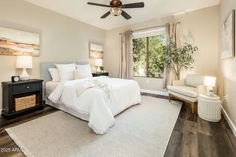 a spacious bedroom with a bed and ceiling fan