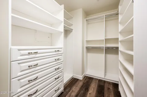 a view of a room with wooden floor fan and windows