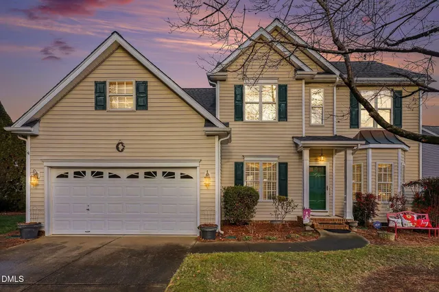 a view of a house with large windows and a table and chairs under an umbrella