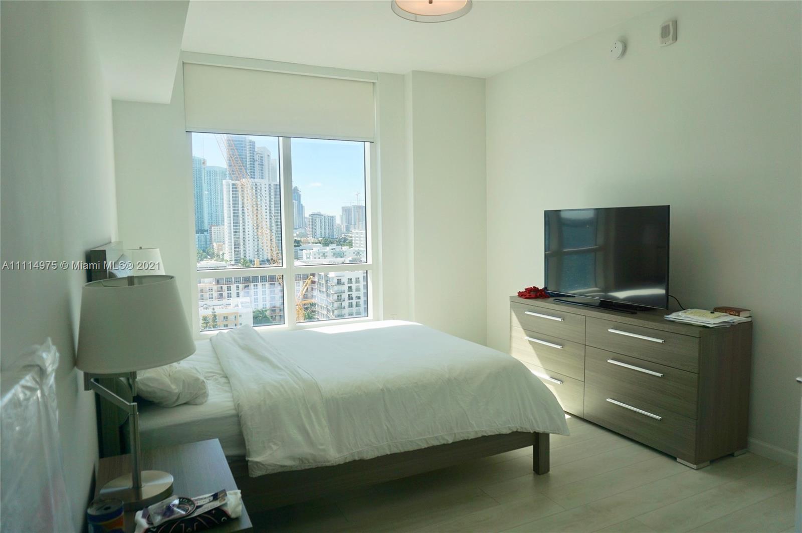 601 Northeast 27th Street, Unit 1604 Miami, FL 33137 - Photo 8 of 47 a bedroom with a bed and a flat tv screen on the dresser
