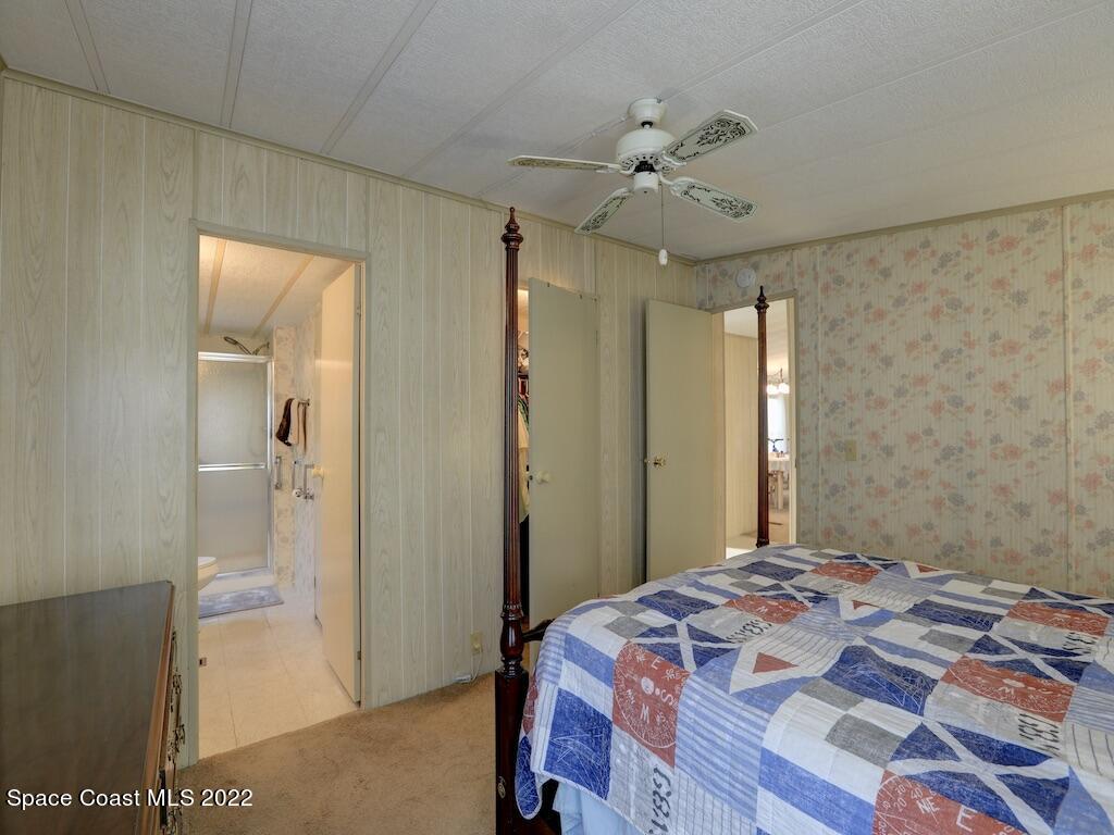 622 Wedelia Drive Sebastian, FL 32976 - Photo 21 of 29 a bedroom with a bed and a chandelier