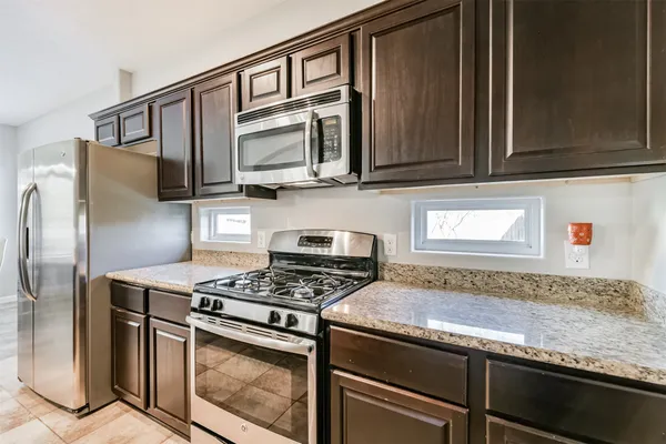 a kitchen with stainless steel appliances granite countertop a stove microwave and refrigerator