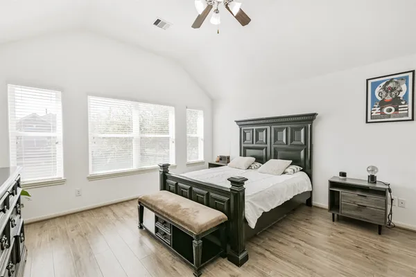 a bedroom with a bed a couch and a large window