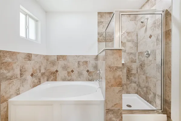 a bathroom with a white bath tub and a shower