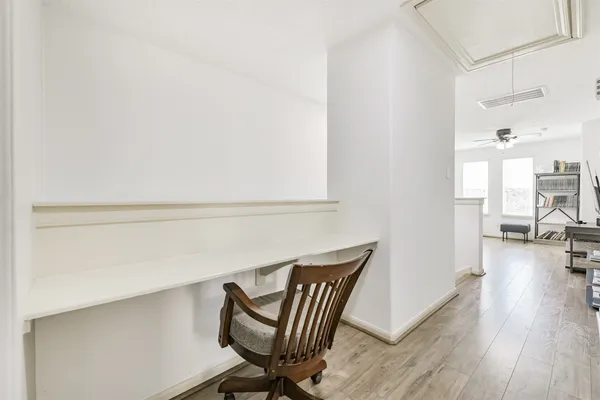 a view of a workspace with furniture and wooden floor