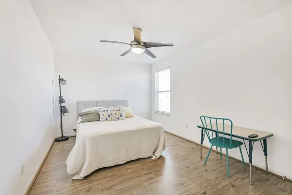 a bedroom with a bed paintings on the wall and a window