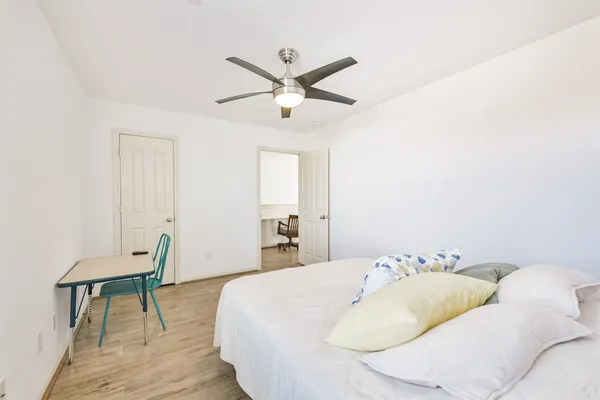 a spacious bedroom with a bed and a chandelier