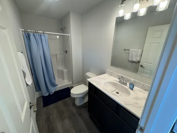 a bathroom with a sink vanity granite and toilet