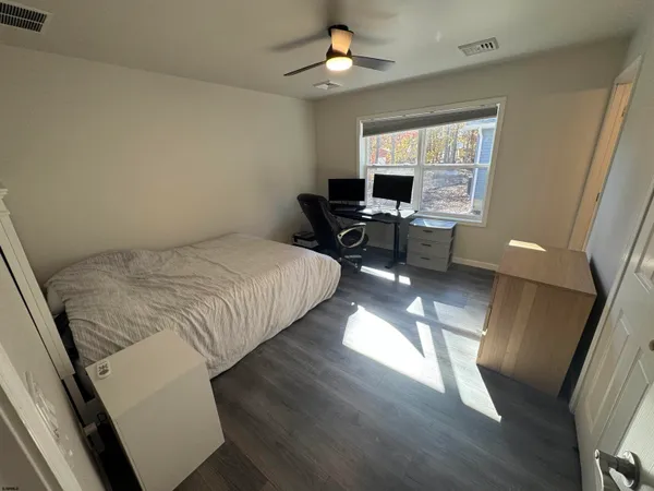 a bedroom with a bed a chair and a chandelier