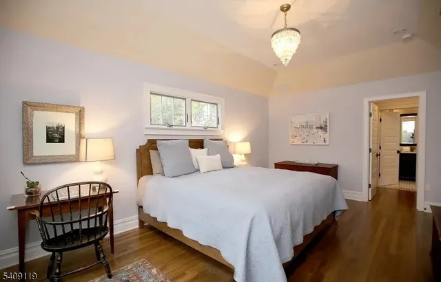a bedroom with bed and wooden floor