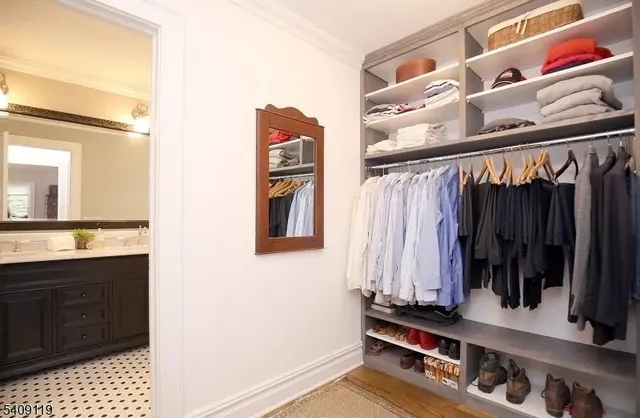 a view of walk in closet with clothes and shoes