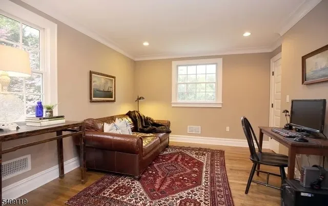 a living room with furniture and a flat screen tv with wooden floor