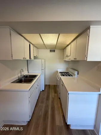 a kitchen with stainless steel appliances granite countertop a sink a stove and a refrigerator