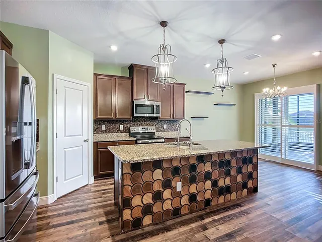 a kitchen with granite countertop a refrigerator and a sink