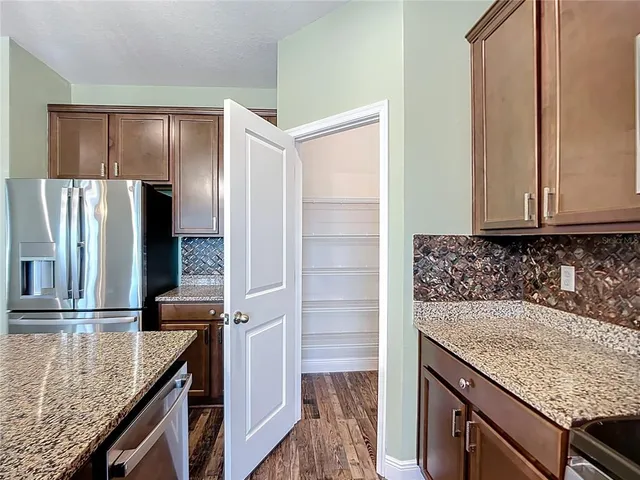 a kitchen with stainless steel appliances a refrigerator and a stove top oven