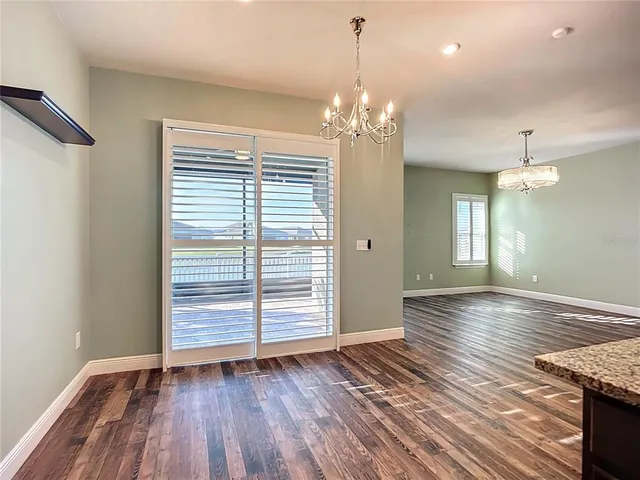 a large kitchen with stainless steel appliances kitchen island granite countertop a refrigerator and a stove top oven