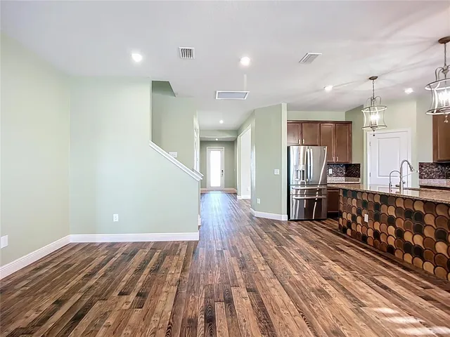 a view of a hallway with wooden floor and entryway