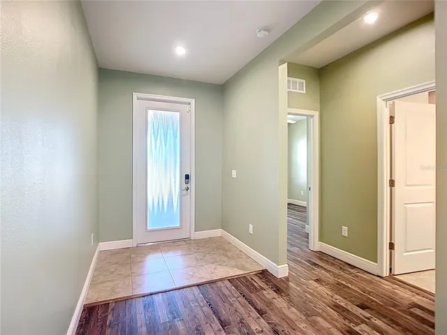 a view of an empty room with wooden floor