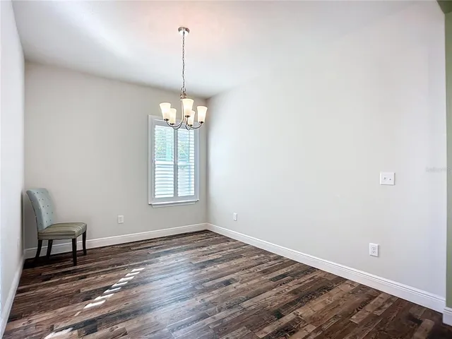 a large kitchen with sink a microwave a stove and wooden floors