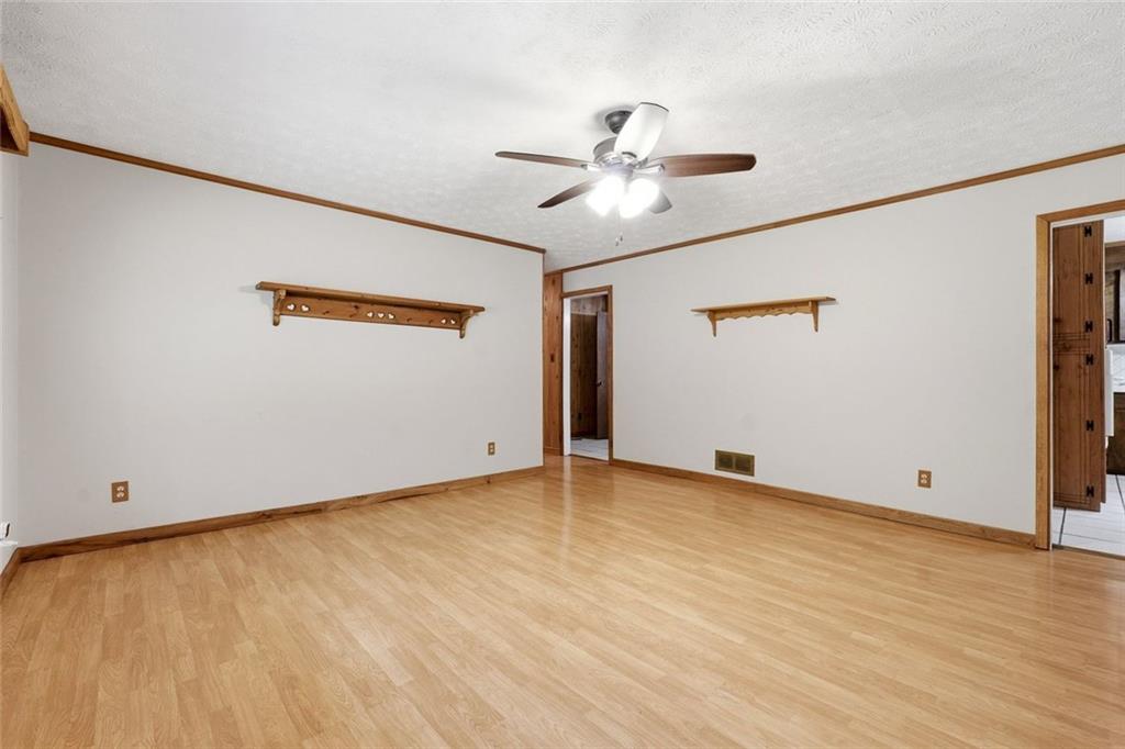 399 Donahoo Road Southeast Silver Creek, GA 30173 - Photo 5 of 22 a view of an empty room with wooden floor and a ceiling fan