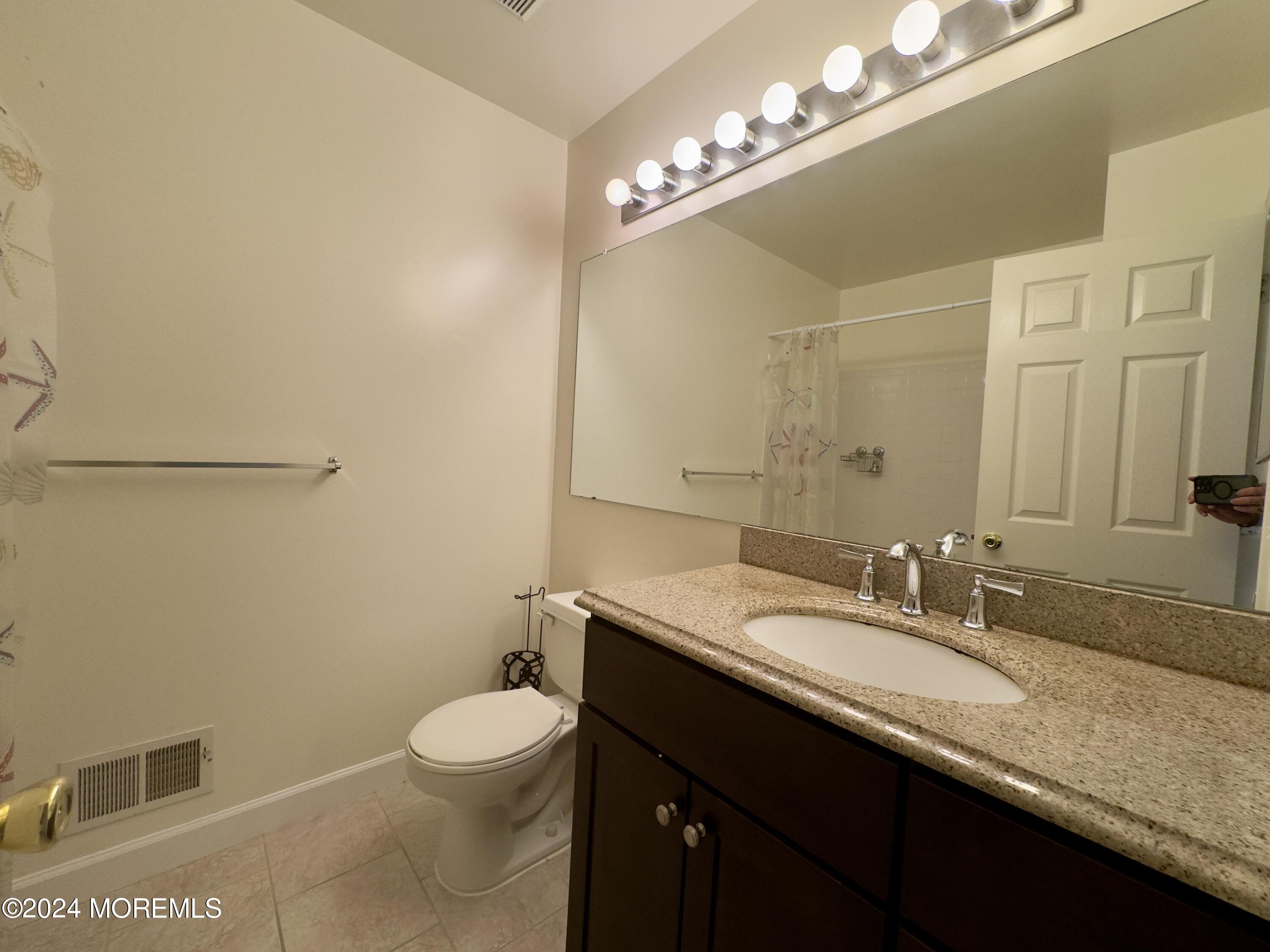 28 Alpine Road, Unit 177 Holmdel, NJ 07733 - Photo 14 of 17 a bathroom with a granite countertop sink a toilet a mirror and shower