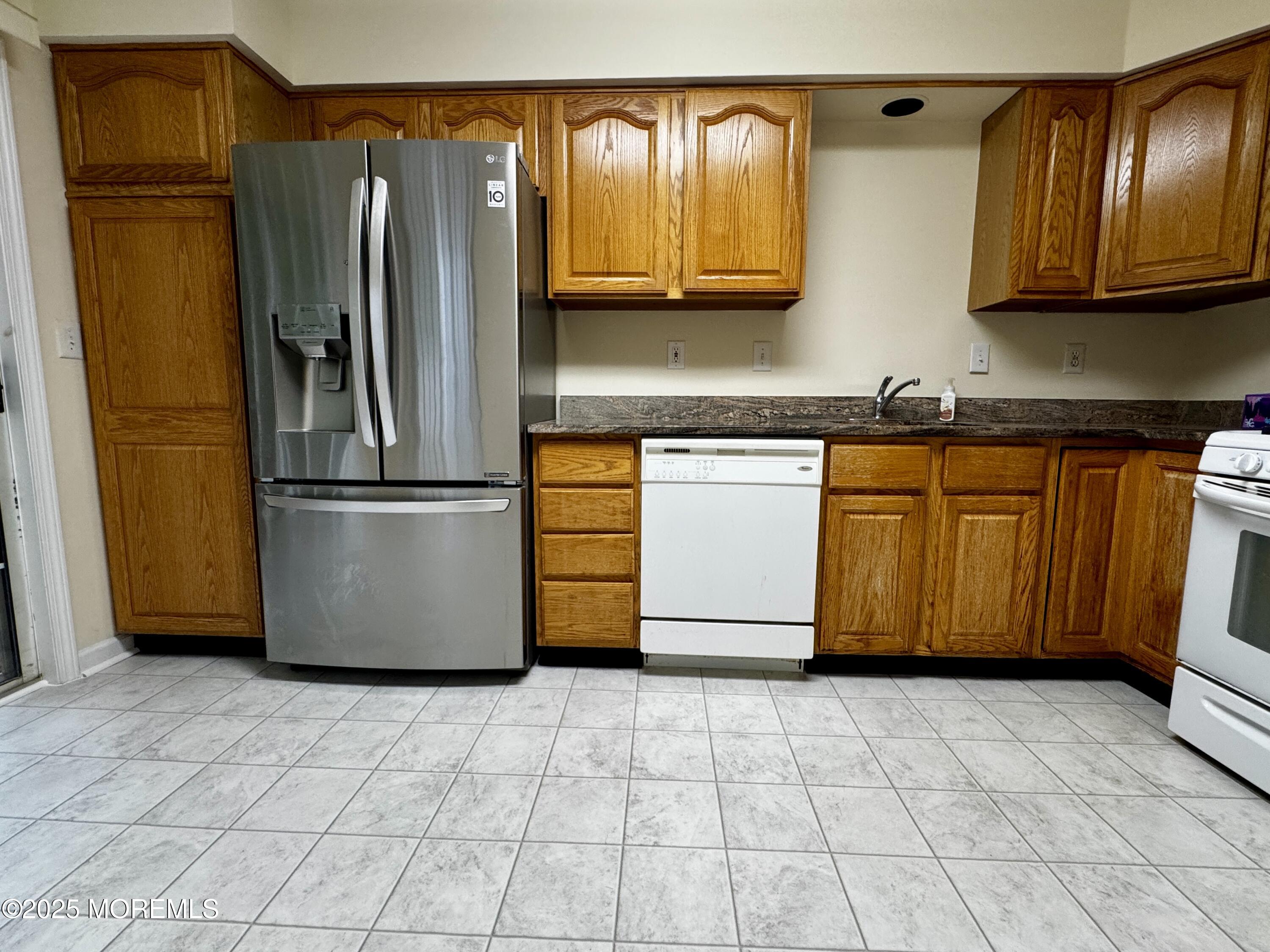 28 Alpine Road, Unit 177 Holmdel, NJ 07733 - Photo 7 of 17 a kitchen with stainless steel appliances granite countertop a refrigerator a stove and a sink