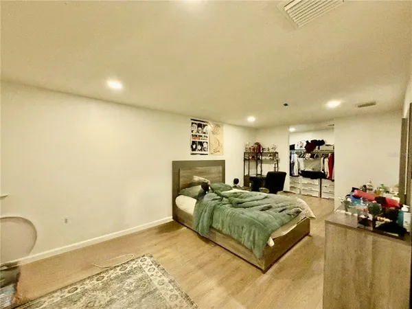 a bedroom with a bed and wooden floor