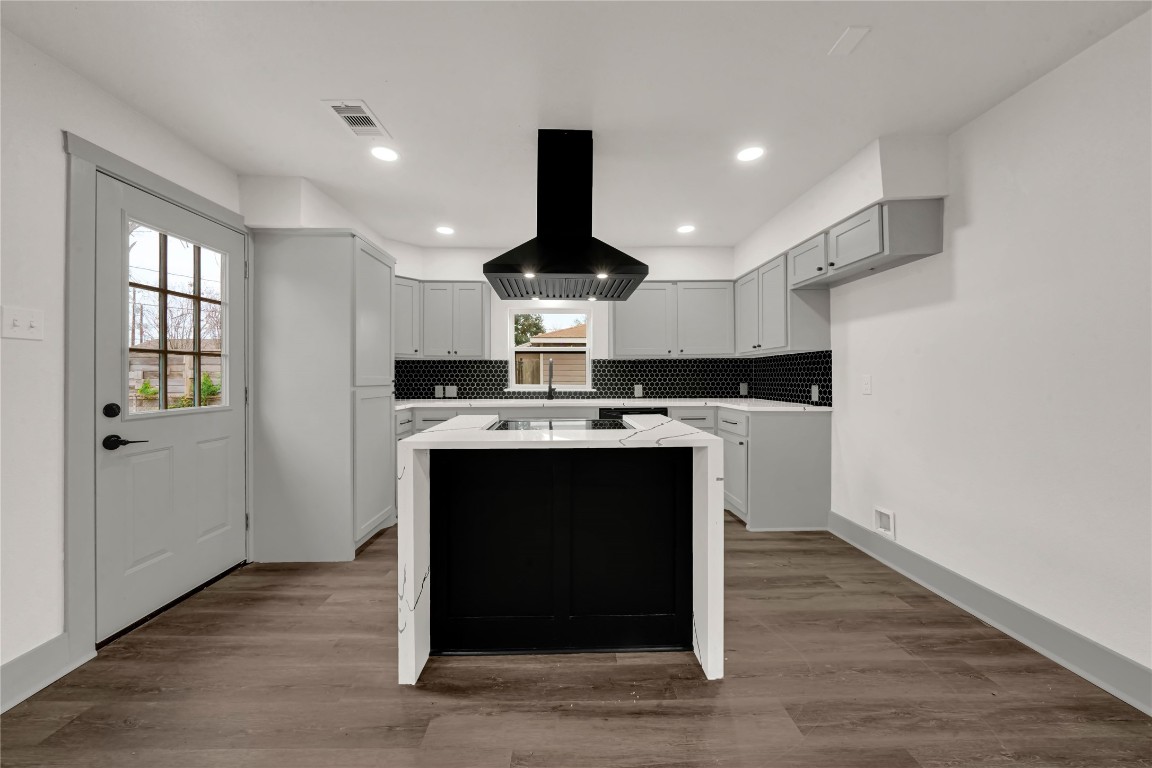 4331 Herridge Street Houston, TX 77022 - Photo 6 of 32 a kitchen with kitchen island stainless steel appliances a sink cabinets and wooden floor