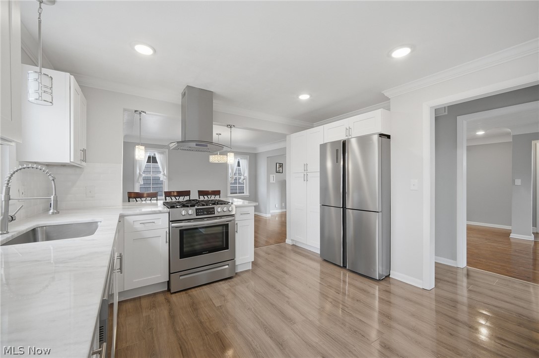 3722 Lindholm Road Shaker Heights, OH 44120 - Photo 17 of 34 Kitchen featuring white cabinetry, stainless steel appliances, a white marble-effect countertop, and light wood flooring