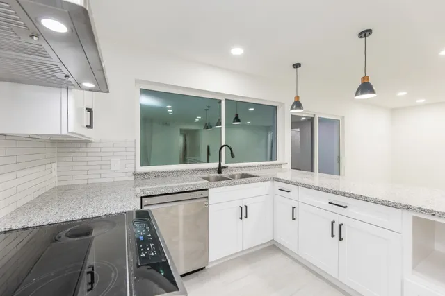 a kitchen with a sink and white cabinets