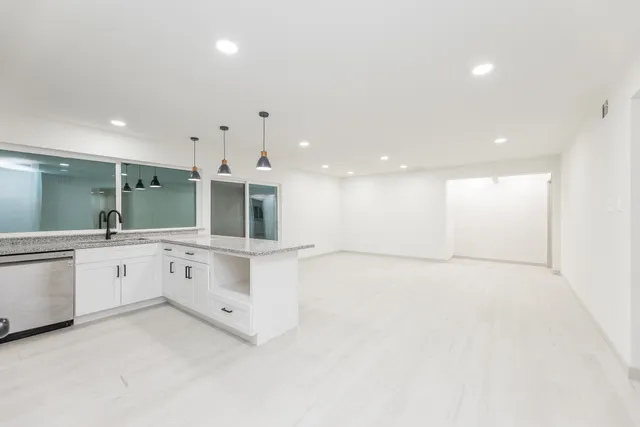 a large white kitchen with a large window