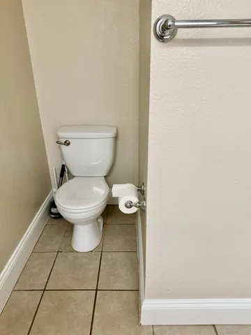 a white toilet sitting next to a shower