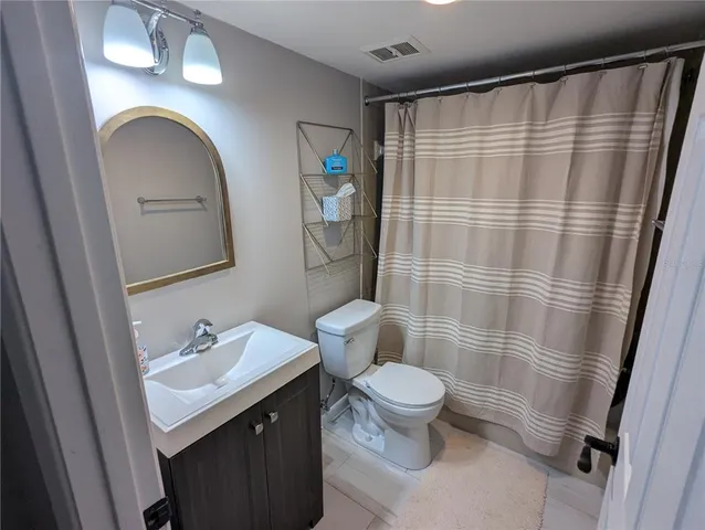 a bathroom with a sink a toilet and shower curtain