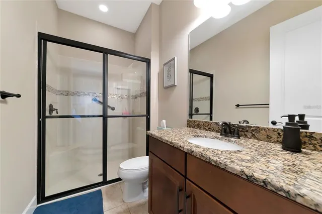 a bathroom with a granite countertop sink mirror and toilet
