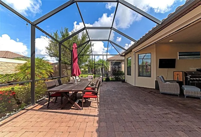 a view of a patio with a table and chairs under an umbrella